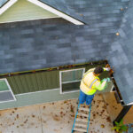 a-worker-is-cleaning-clogs-in-roof-gutter-drain